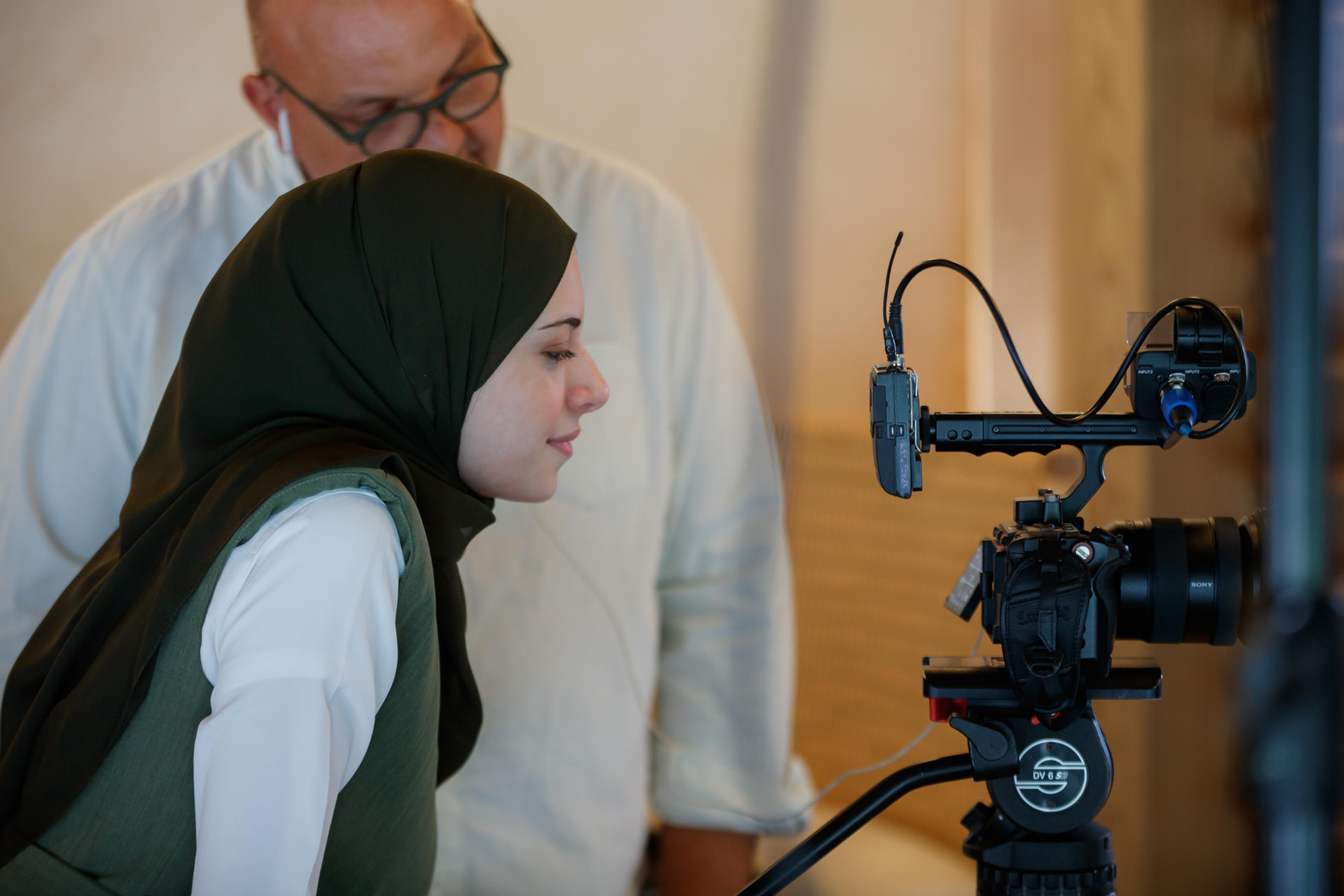 Rahma checking the camera frame on set